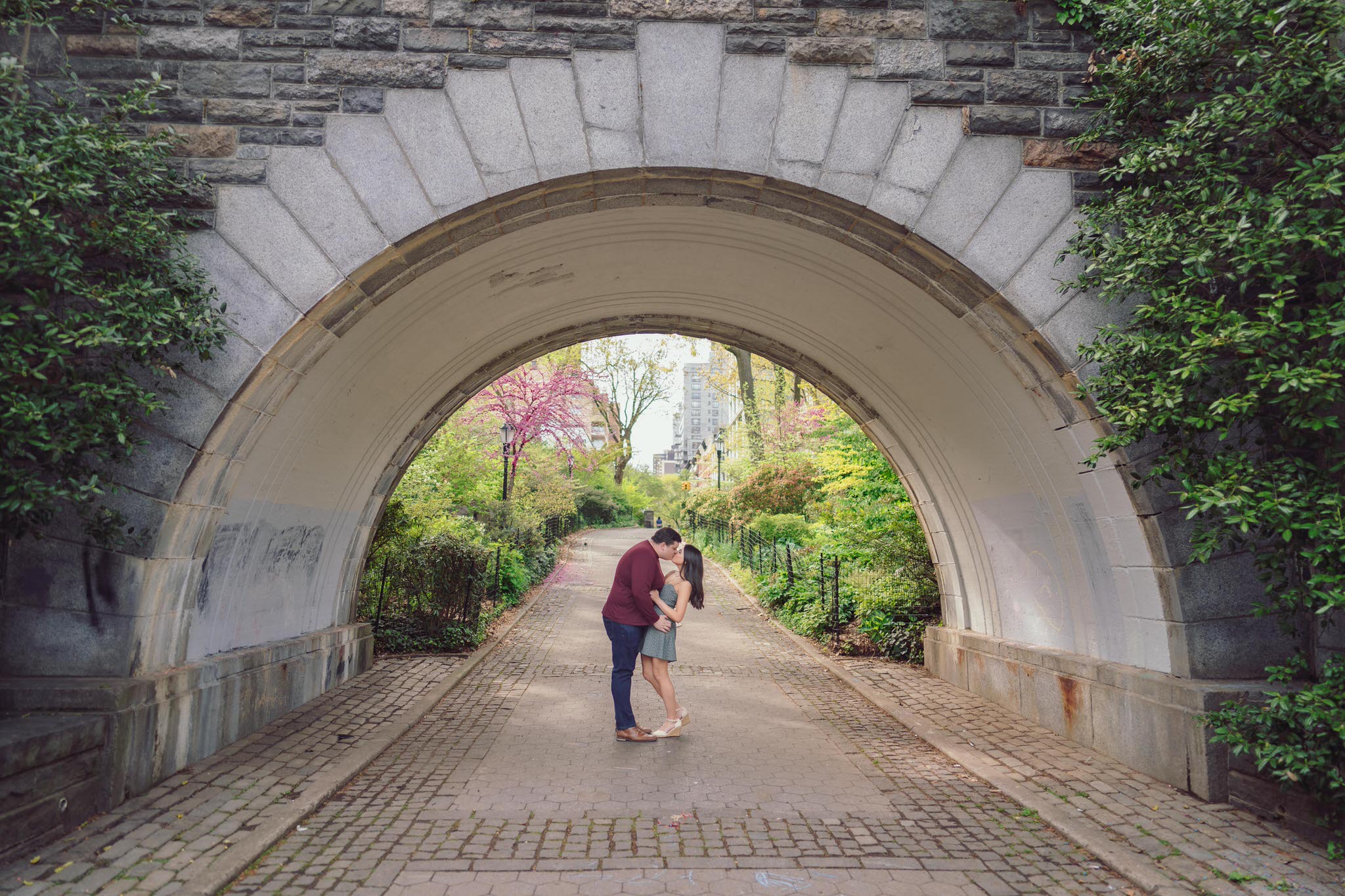 a couple under a bridge kissing