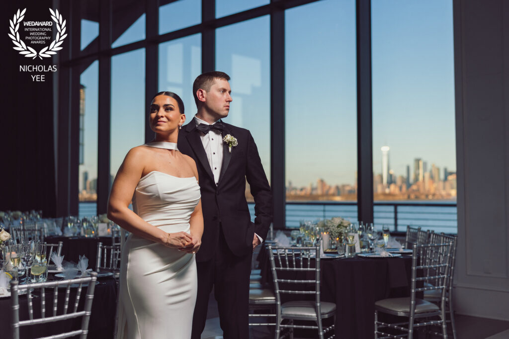 Elegant wedding portrait of a couple in front of a stunning city skyline captured by an award-winning wedding photographer.