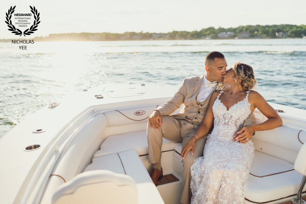 Newlywed couple sharing a kiss aboard a boat in an award-winning wedding photograph by Nicholas Yee Photography.